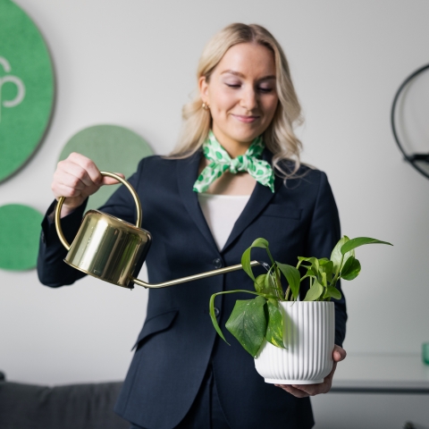 Pankin asiantuntija kastelee kastelukannulla ruukkukasvia.