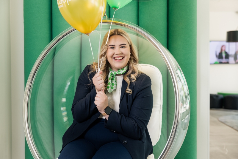 OmaSp:n asiantuntija istuu ilmapallojen kanssa