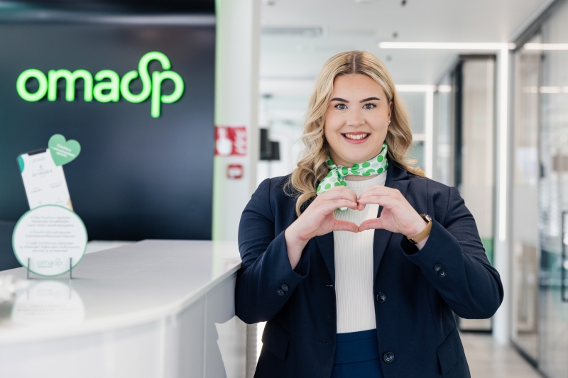 OmaSp:n asiantuntija hymyilee ja muodostaa käsillä sydämen