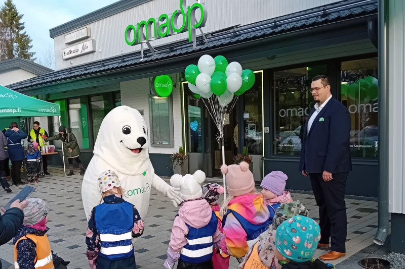 Lapset tervehtimässä Norppa-maskottia pankin pihassa.