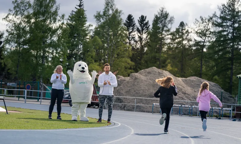 Lasten juoksukisat urheilukentällä.